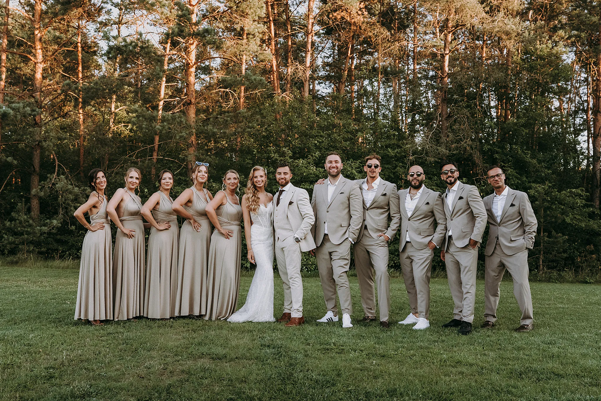 Wspólne zdjęcie pary młodej z druhnami i drużbami pełne naturalnego śmiechu i dynamiki – Studio Grygierczyk